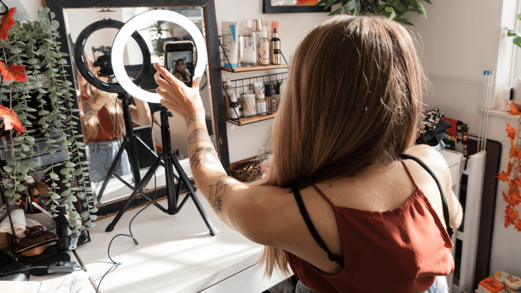 Influenceur in front of her mirror with a light ring and her phone filming herself